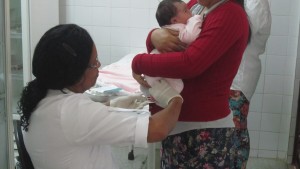 Graça realiza, na sala de vacina, a coleta na pequena Ana Júlia, no 4º dia de vida. Foto: Rafaella Arruda.