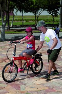 Voluntário do Bike Anjo orienta criança em sua bicicleta. Foto: Foca Lisboa/ UFMG